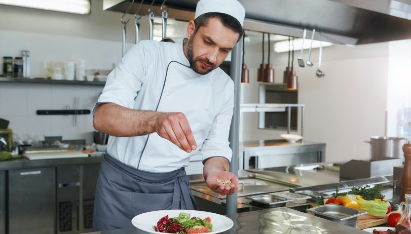 Chase the flavors. ook preparing dish for serving. Modern commercial kitchen