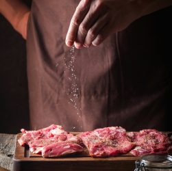 Man cooking meat steaks