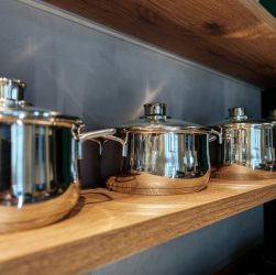 Shining new metal pots on open shelves in store