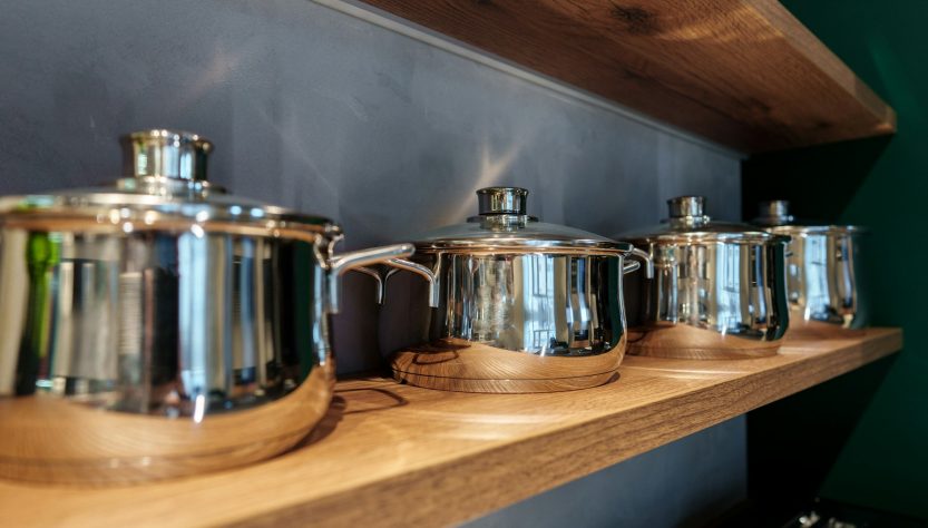 Shining new metal pots on open shelves in store