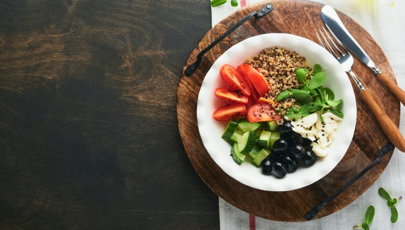 Vegetarian Vegan salad bowl or buddha bowl with tomato, cucumber, mozzarella cheese, quinoa, olives