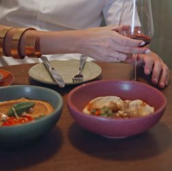 Woman hand holding wineglass at cafe closeup. Spouses tasting lebanese cuisine